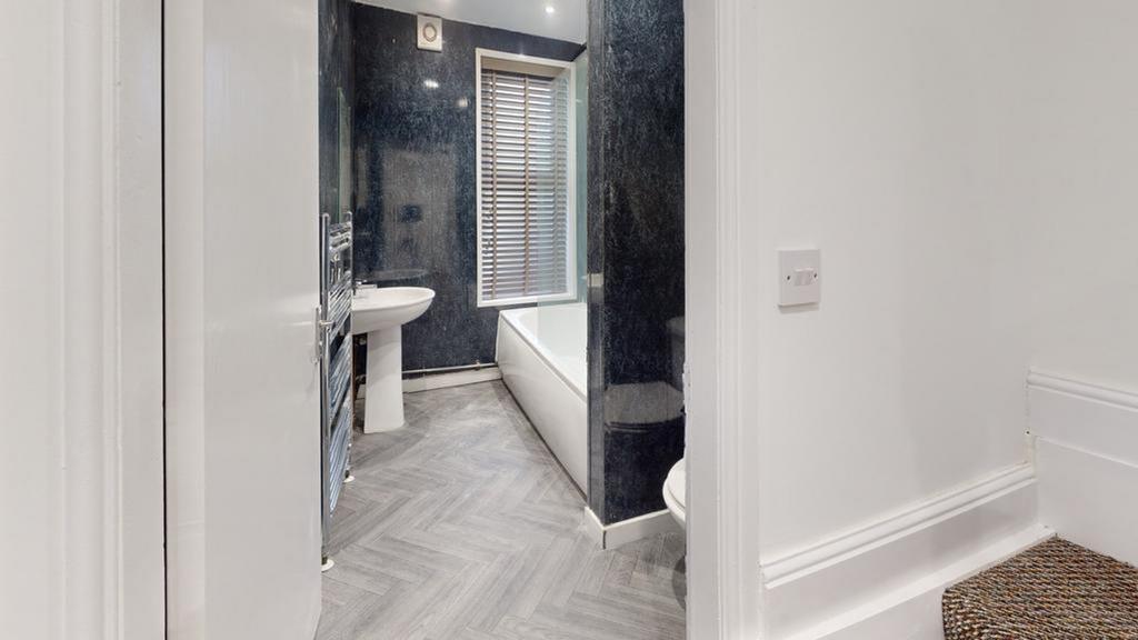 A spacious and modern bathroom featuring a rela...