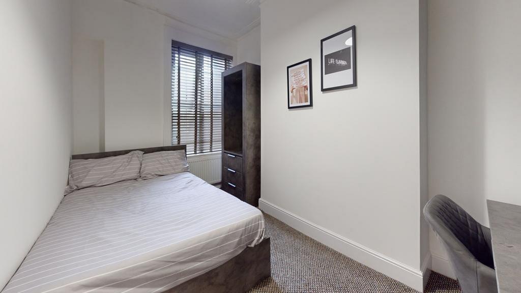 A cozy and well-lit double bedroom featuring mo...