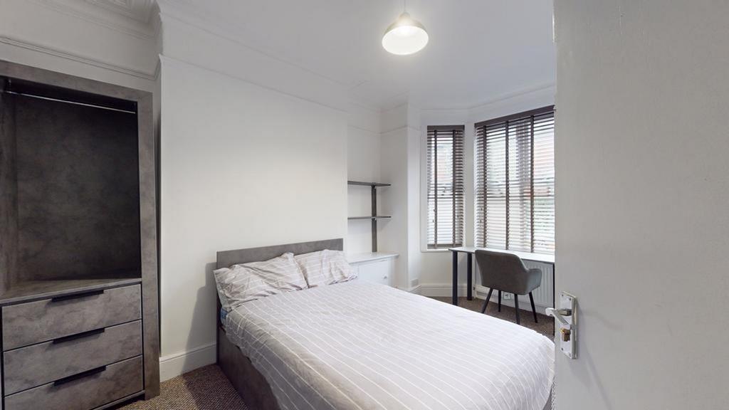 A bright and tidy double bedroom featuring a co...