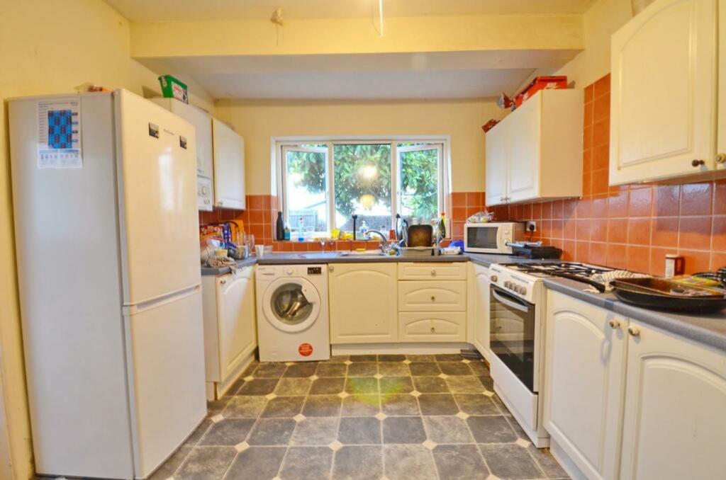 A spacious and bright kitchen with ample storag...