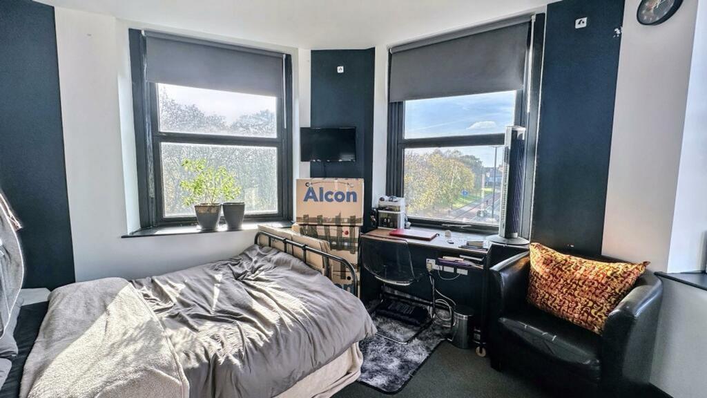 A bright and cozy double bedroom featuring larg...