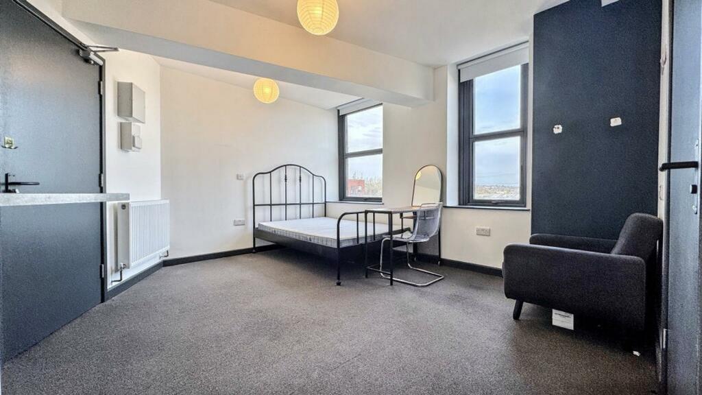 A spacious and well-lit double bedroom, perfect...