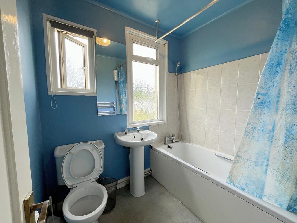 A bright and tidy bathroom featuring a bath and...