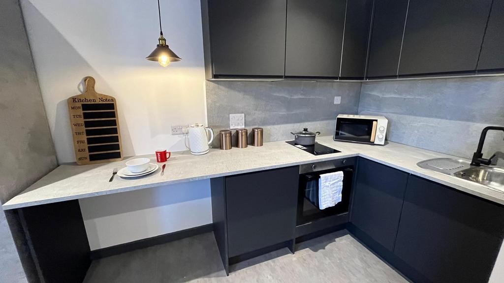 A modern kitchen featuring sleek black cabinetr...