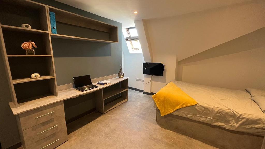 A neat and modern single bedroom featuring a bu...