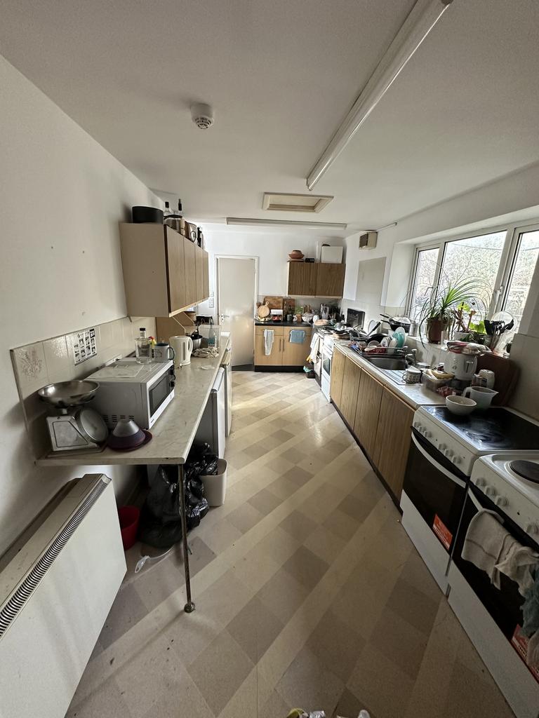 A spacious kitchen with ample natural light, pe...