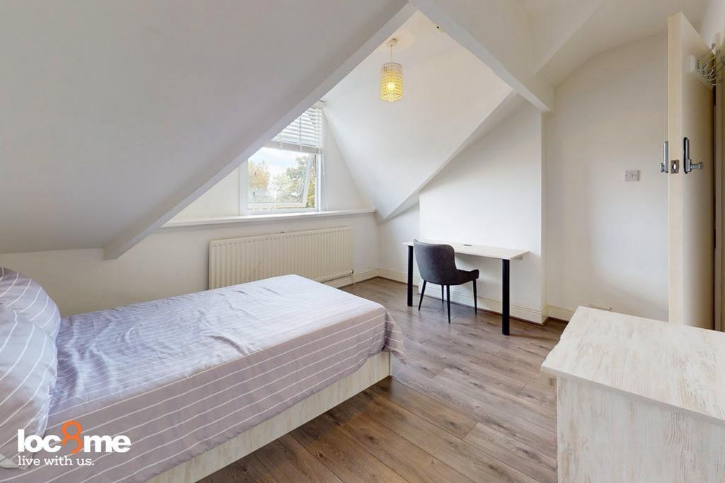 A bright and tidy double bedroom featuring a co...