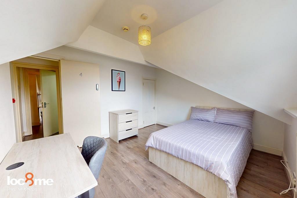A spacious and well-lit double bedroom, perfect...
