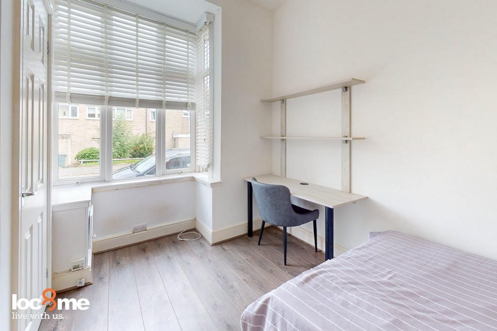 A bright and tidy double bedroom featuring a wo...