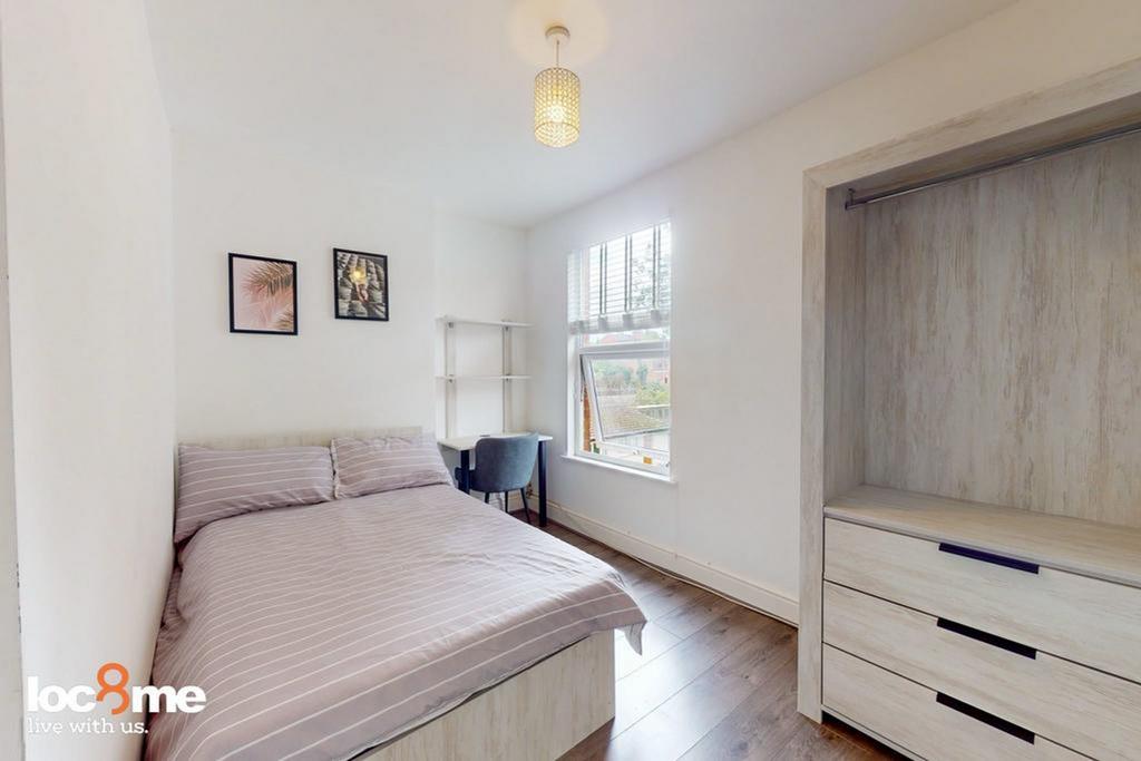 A cozy and well-lit double bedroom featuring a ...
