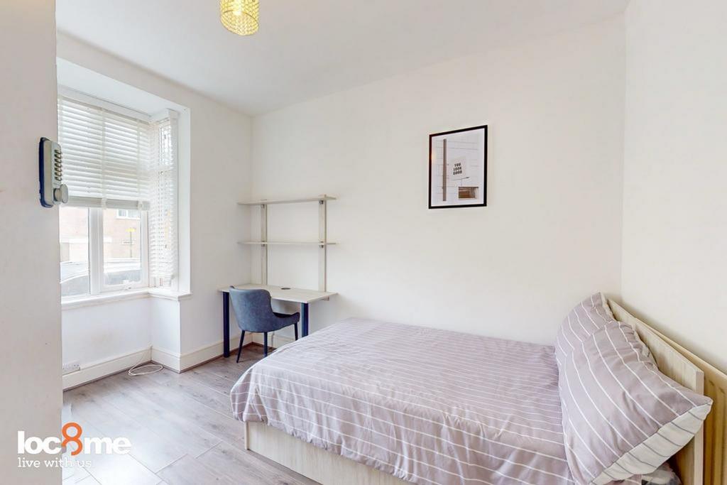 A bright and tidy double bedroom featuring a co...