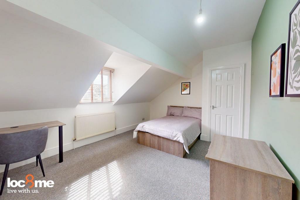 A bright and spacious double bedroom with moder...