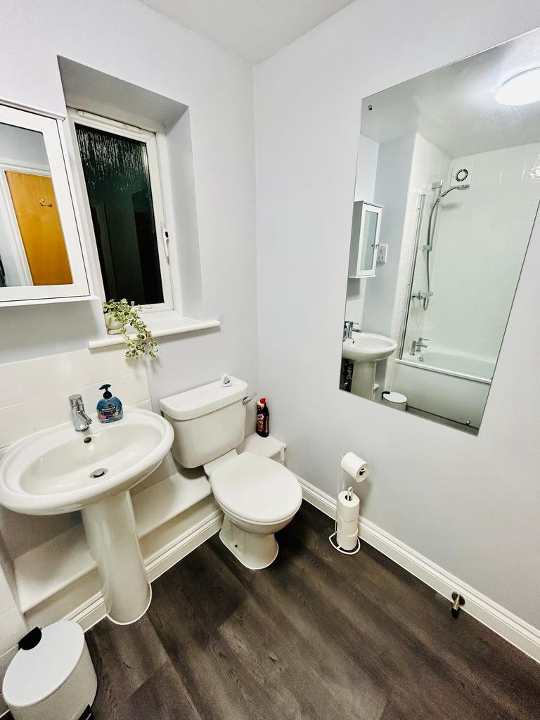 A tidy and modern bathroom featuring a bath and...