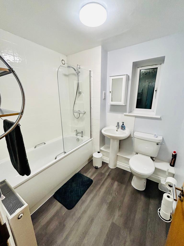 A clean and modern bathroom featuring a bath an...