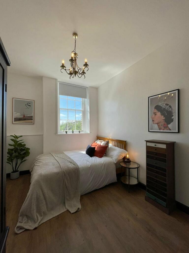 A bright and inviting double bedroom with styli...