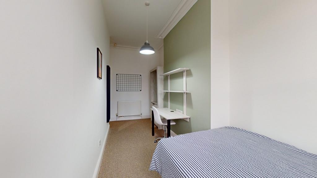 A spacious and tidy double bedroom featuring a ...