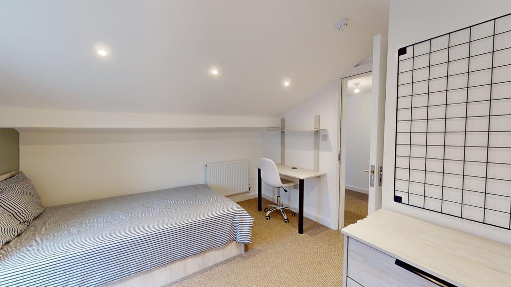 A spacious and well lit double bedroom featurin...