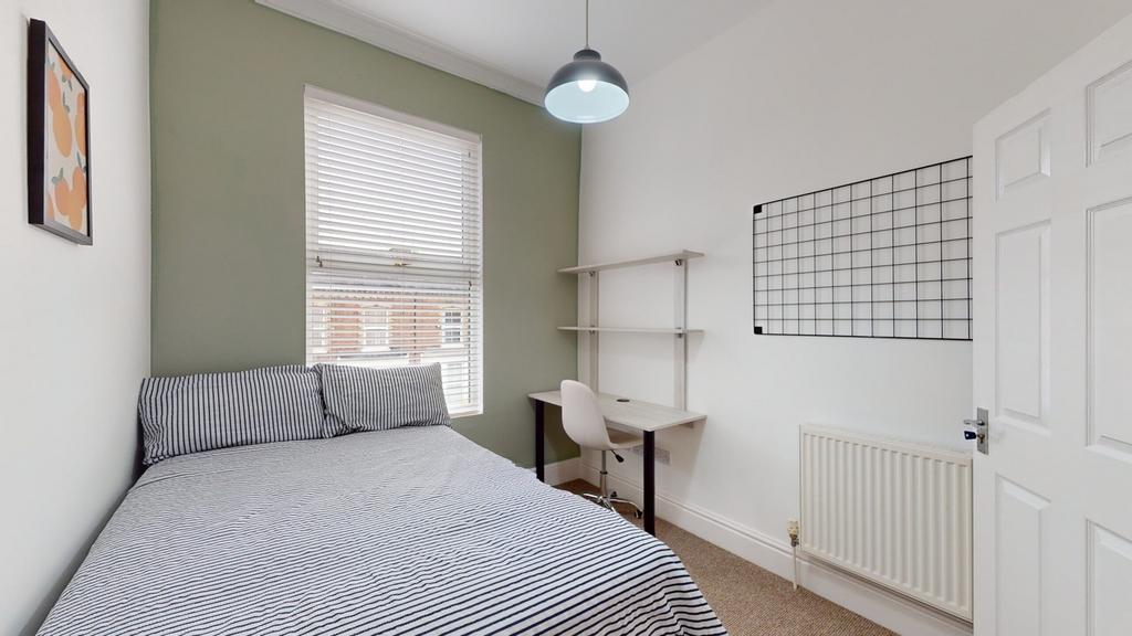 A bright and tidy double bedroom featuring a co...