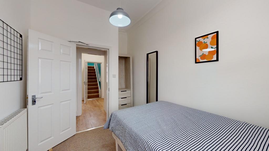 A bright and tidy double bedroom featuring mode...