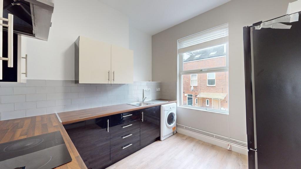 A bright and modern kitchenette with ample coun...