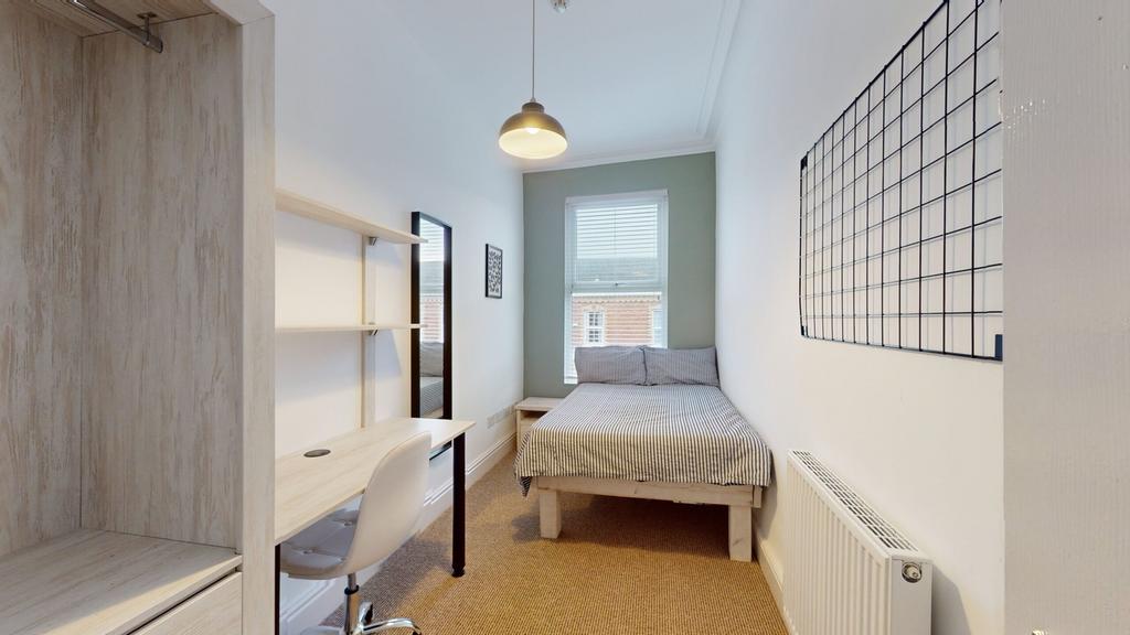 A bright and tidy double bedroom featuring a co...