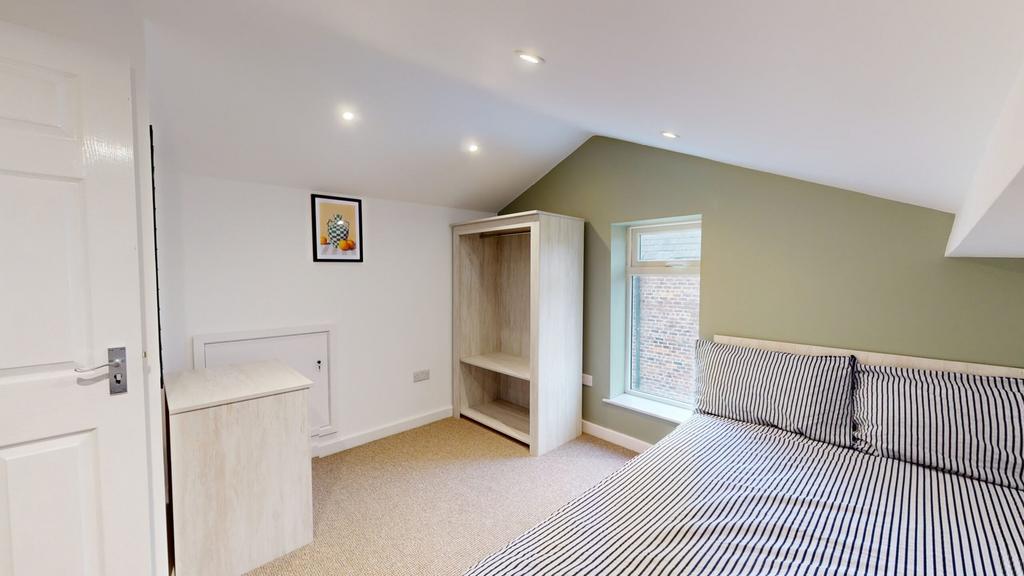 A bright and inviting double bedroom with styli...