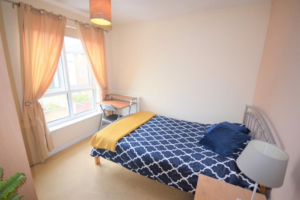 A bright and inviting double bedroom with a coz...