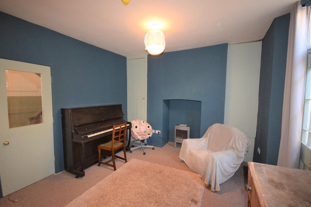 A cozy living room featuring a piano and comfor...