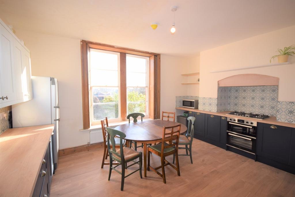 A spacious and bright kitchen with ample natura...