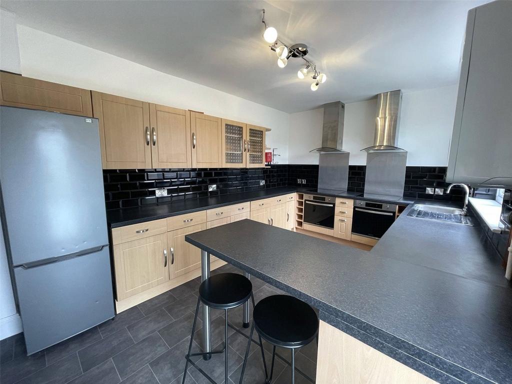 A spacious and modern kitchen featuring sleek c...