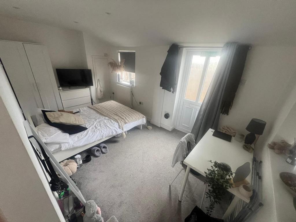 A spacious and bright double bedroom with a coz...