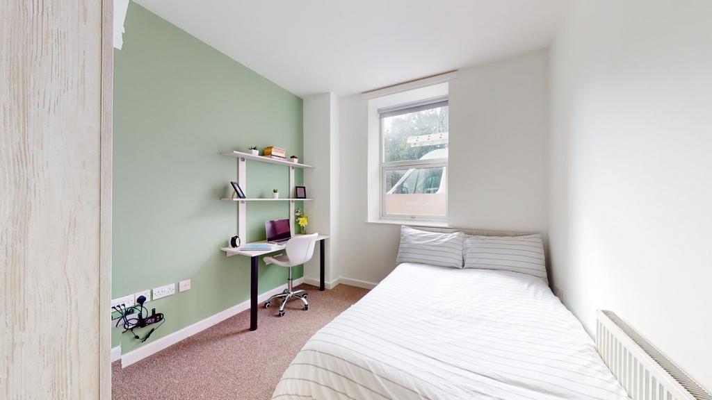 A bright and tidy double bedroom featuring a co...