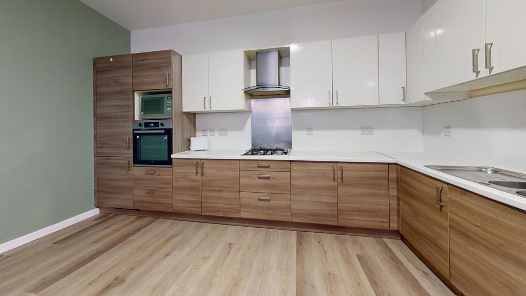 A modern and tidy kitchenette with ample storag...