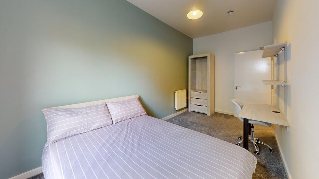 A spacious and well lit double bedroom featurin...