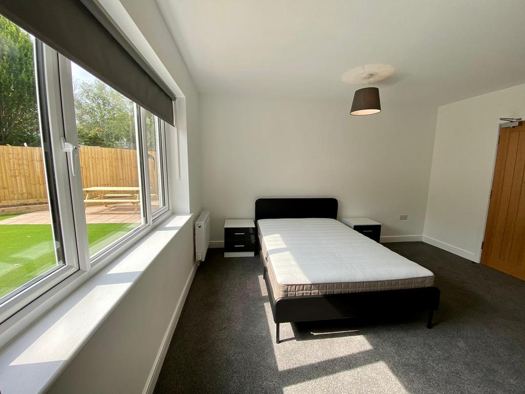 A spacious and bright double bedroom featuring ...