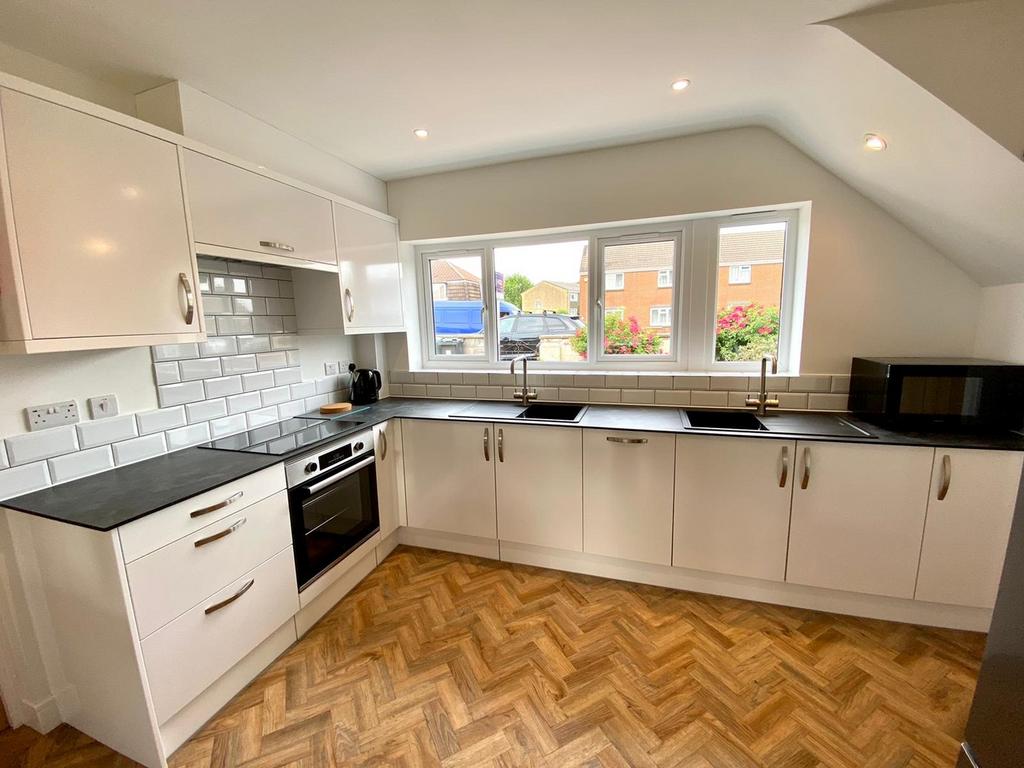 A bright and modern kitchen featuring sleek cab...