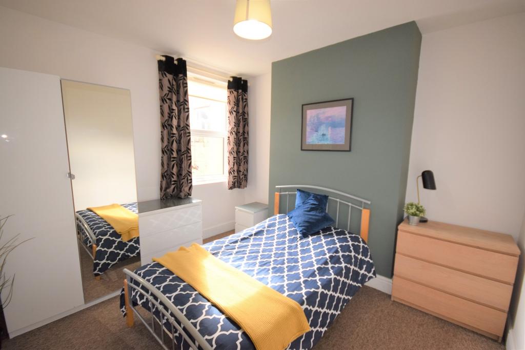 A bright and inviting double bedroom with styli...