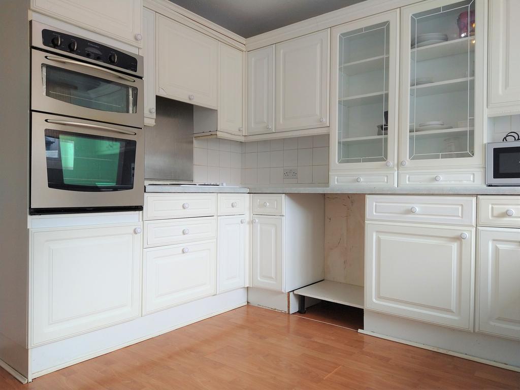 A bright and tidy kitchenette with ample storag...