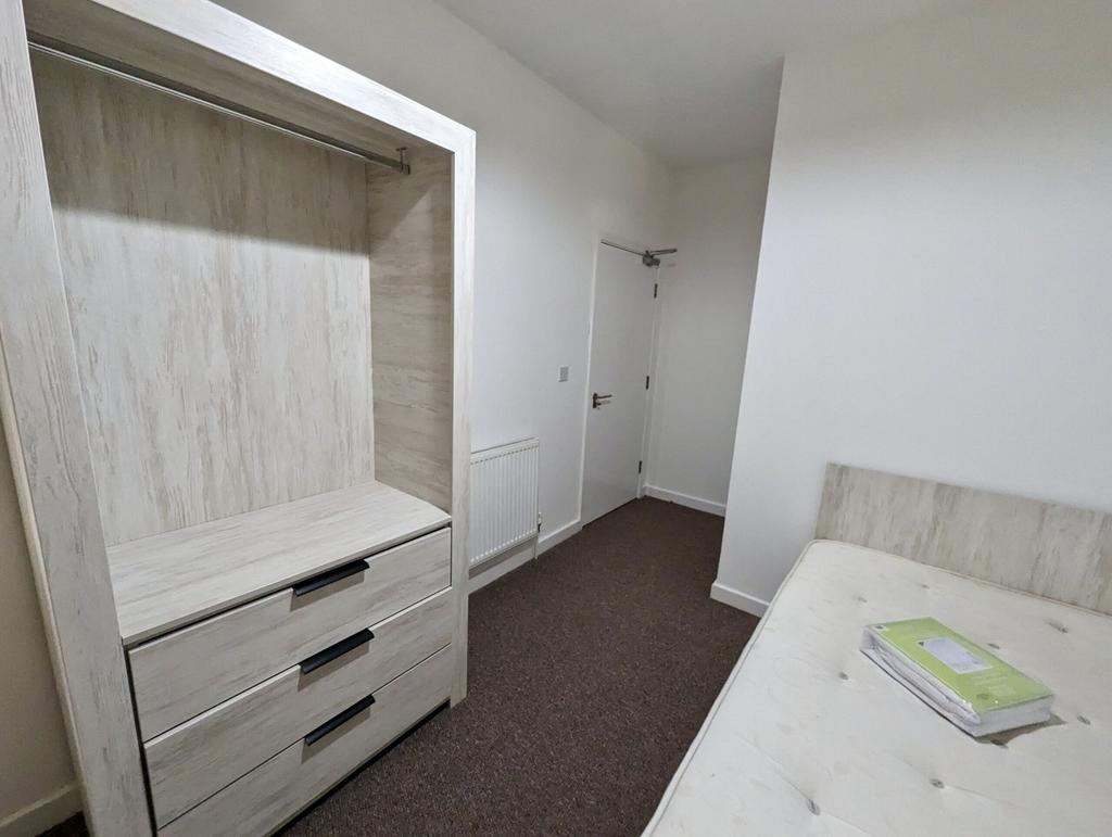 A spacious and tidy double bedroom with ample s...