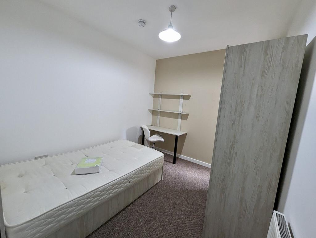 A spacious and tidy double bedroom featuring a ...