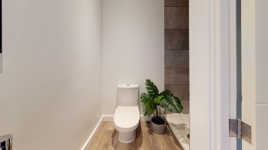 A modern and tidy single toilet space with styl...