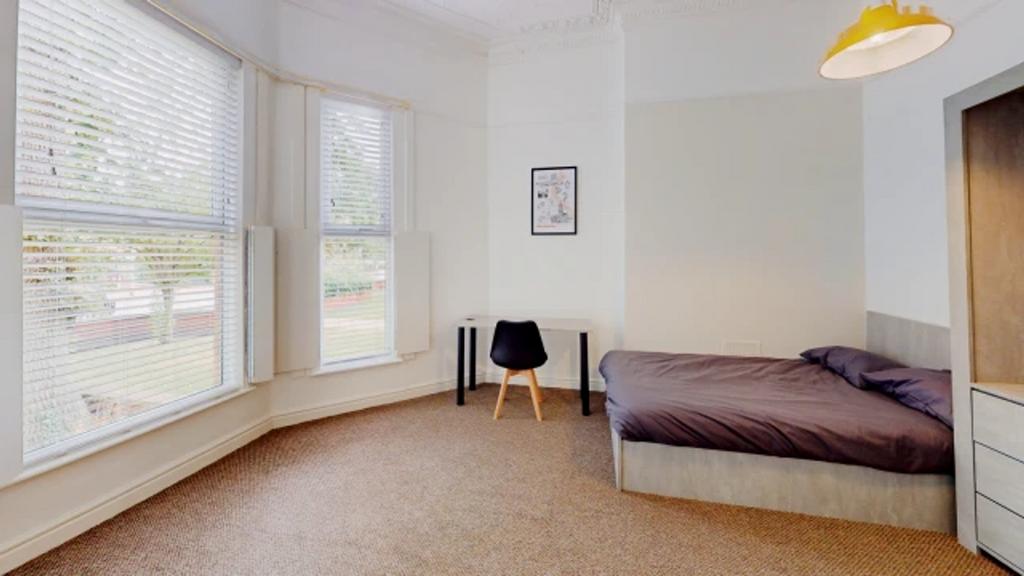 A spacious and bright double bedroom featuring ...