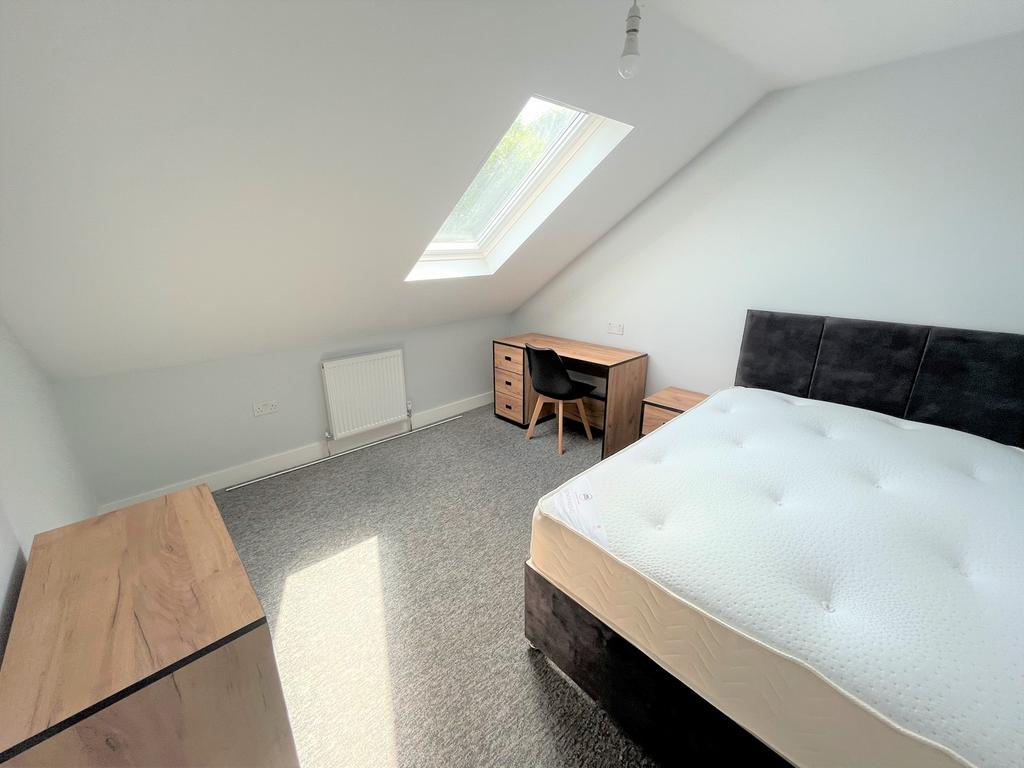 A spacious and bright double bedroom with moder...