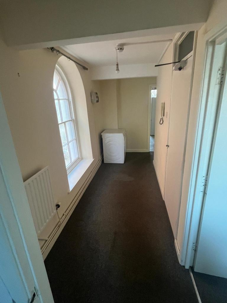 A tidy and spacious hallway with natural light ...