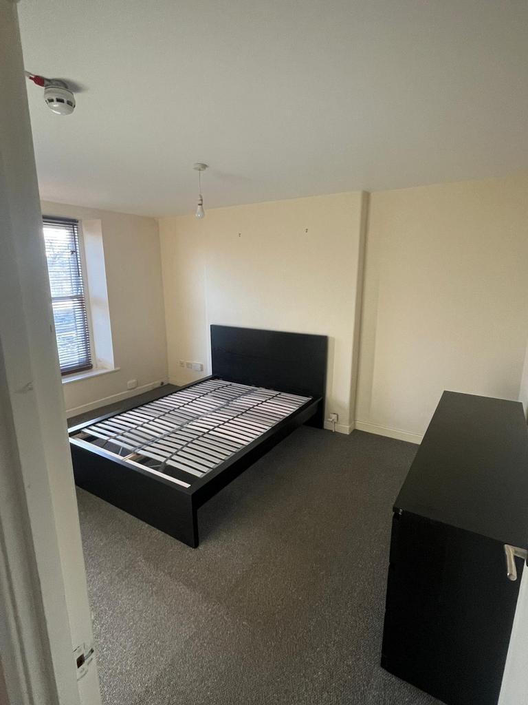 A spacious and well-lit double bedroom, perfect...