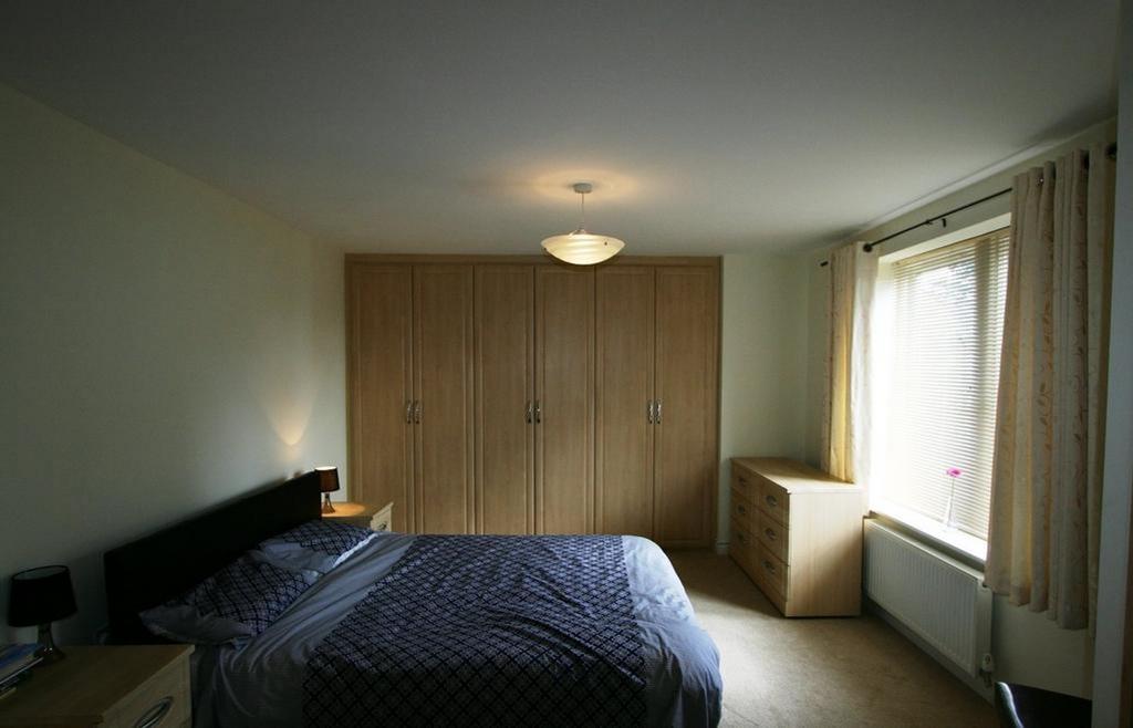 A spacious and well lit double bedroom featurin...