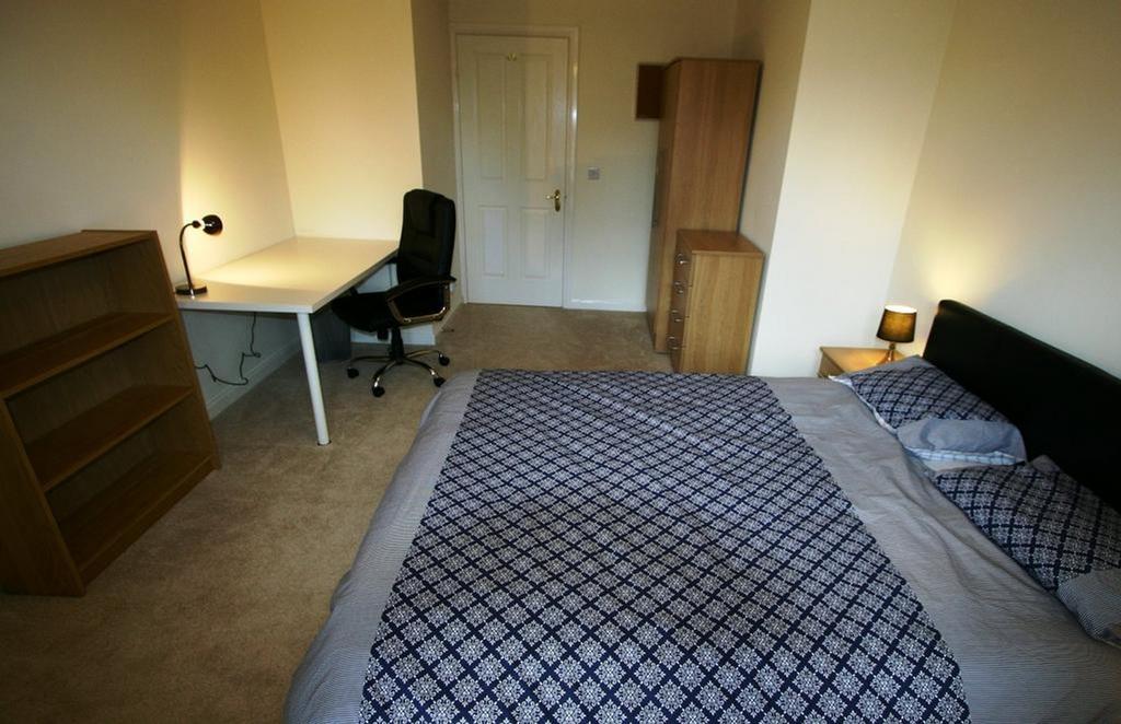 A spacious and well lit double bedroom featurin...