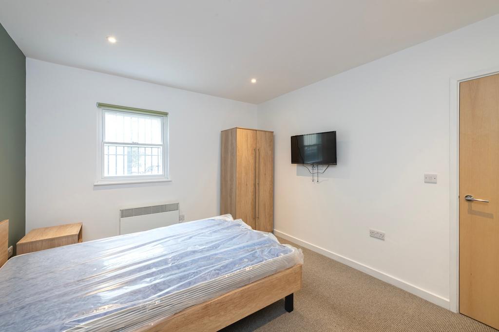 A bright and tidy double bedroom featuring mode...