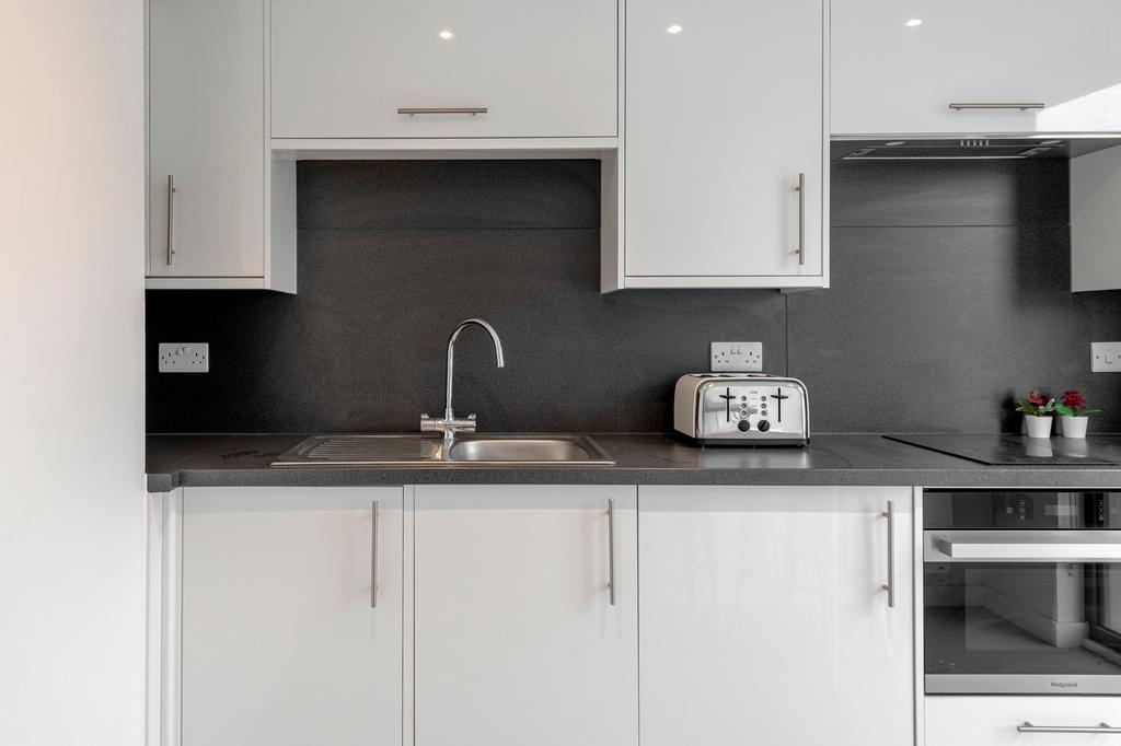 A modern and tidy kitchenette with sleek cabine...