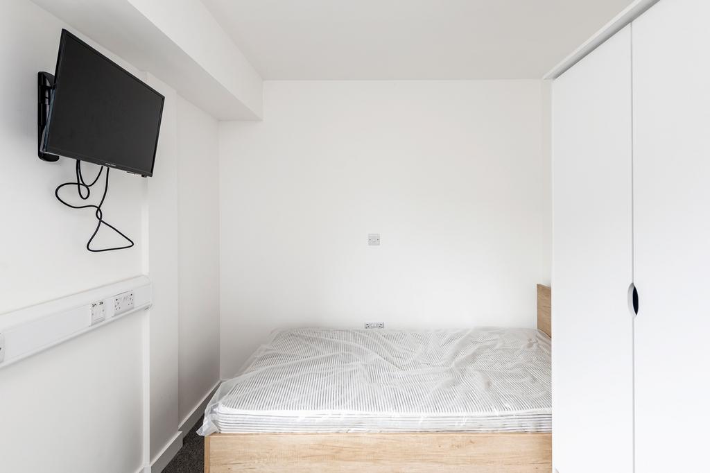 A bright and tidy double bedroom featuring mode...